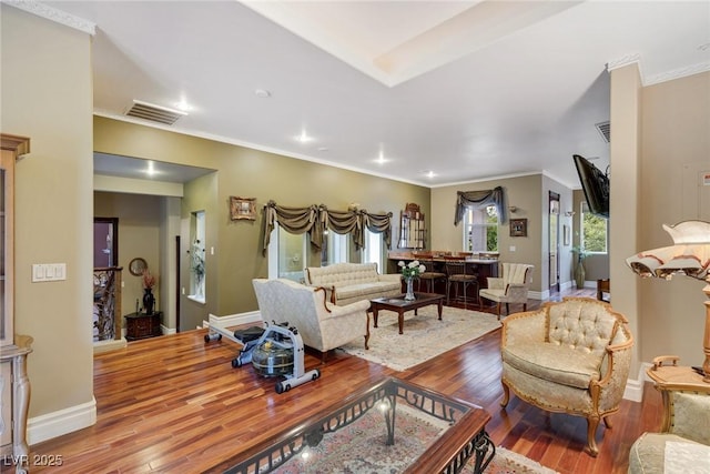 living room featuring hardwood / wood-style flooring and crown molding