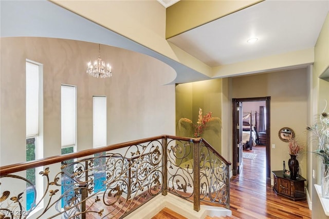 hallway with a notable chandelier and wood-type flooring