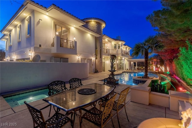 pool at night with a patio area