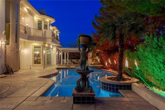 pool at twilight featuring a patio area