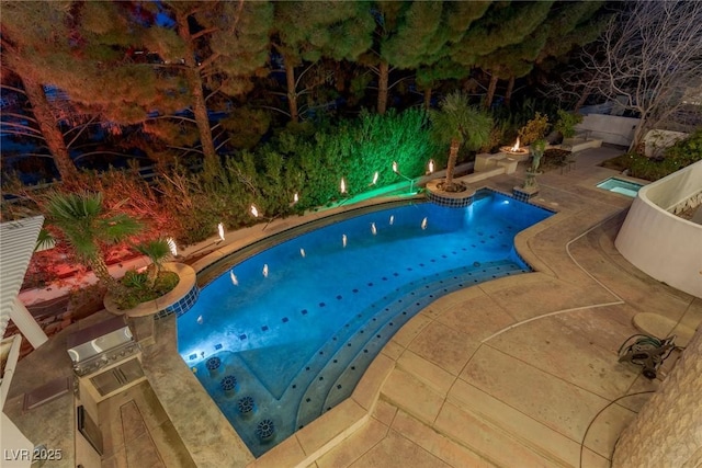 view of swimming pool featuring an outdoor kitchen and a patio area