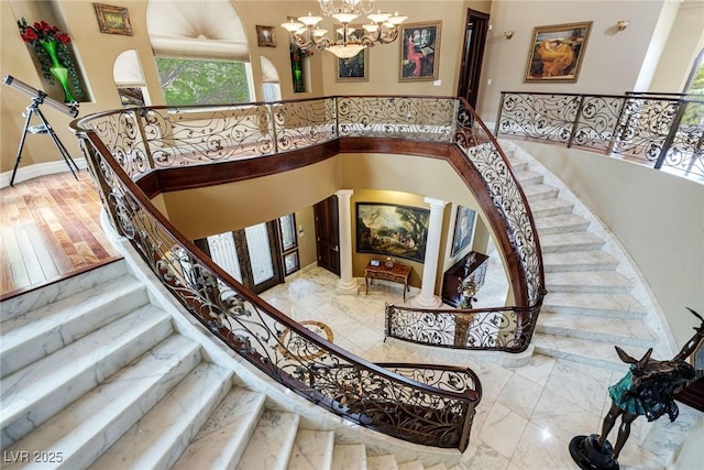 stairway featuring an inviting chandelier and a high ceiling