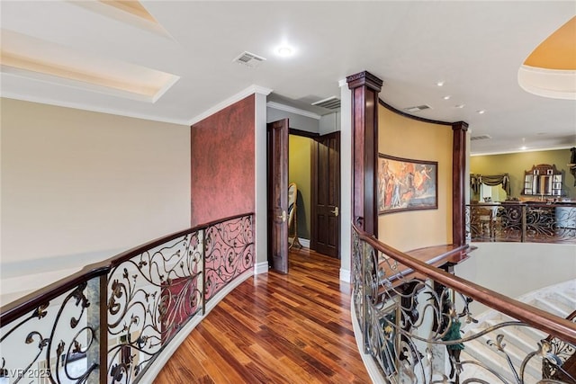 hallway with ornamental molding, dark hardwood / wood-style floors, and decorative columns