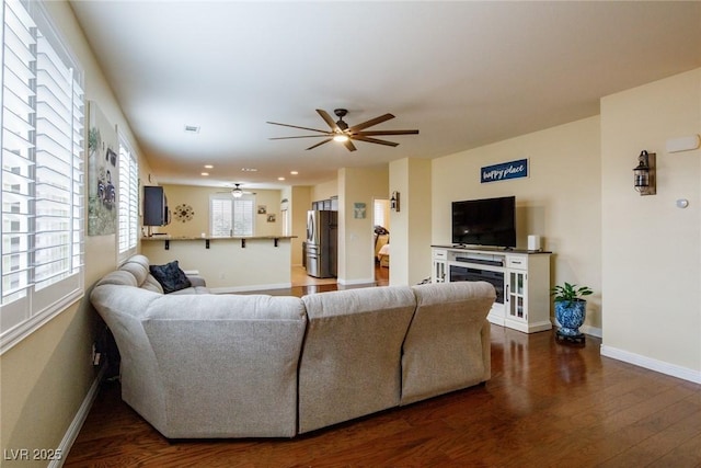 living room with wood-type flooring and ceiling fan