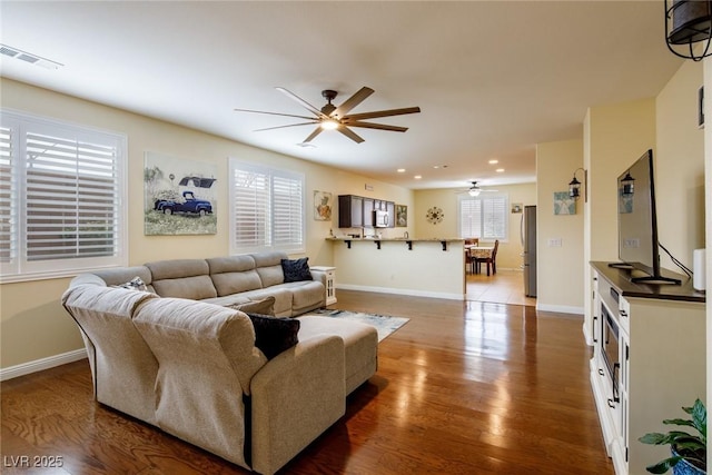 living room with hardwood / wood-style flooring and ceiling fan