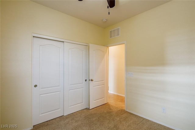 unfurnished bedroom featuring light colored carpet and a closet