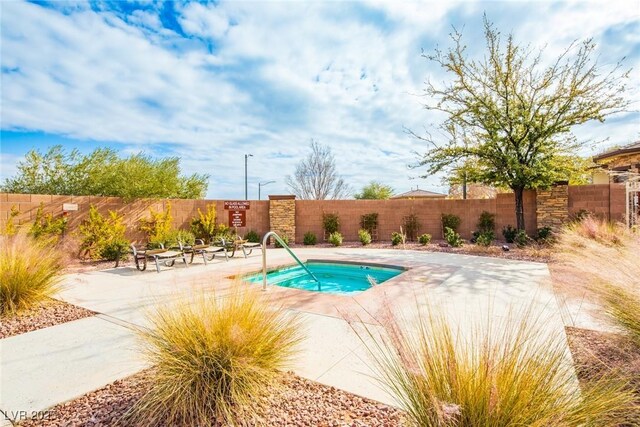 view of swimming pool with a patio and a community hot tub