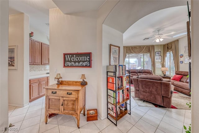 interior space with light tile patterned floors and ceiling fan