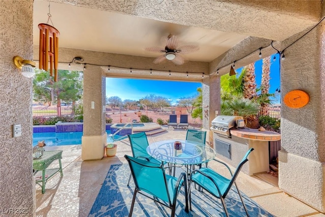 view of patio / terrace with a fenced in pool, grilling area, ceiling fan, and an outdoor kitchen