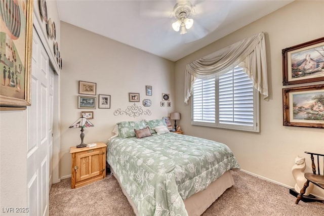 bedroom with light colored carpet, ceiling fan, and a closet