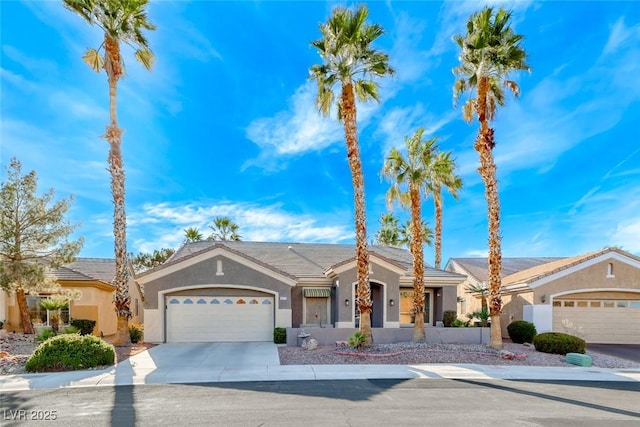 single story home featuring a garage, concrete driveway, and stucco siding