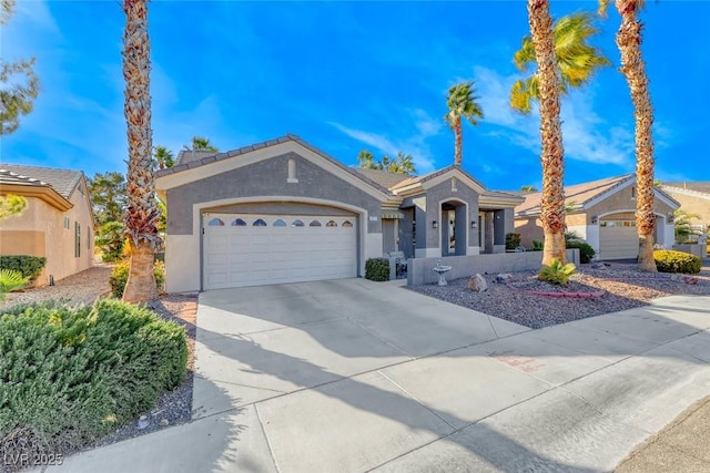 view of front facade with a garage, concrete driveway, and stucco siding