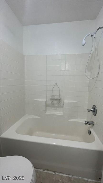 bathroom featuring tub / shower combination and toilet