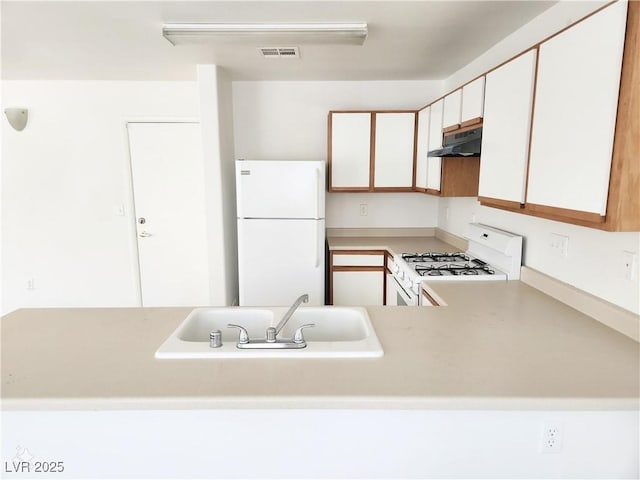 kitchen featuring white cabinetry, white appliances, kitchen peninsula, and sink