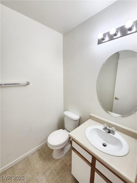 bathroom with vanity, toilet, and tile patterned flooring