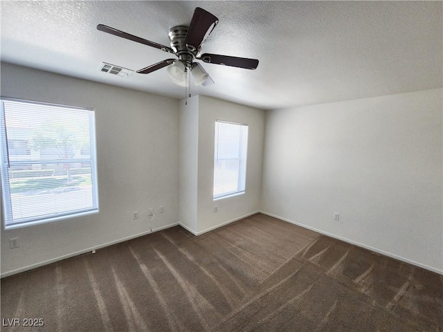 carpeted spare room featuring ceiling fan and a textured ceiling