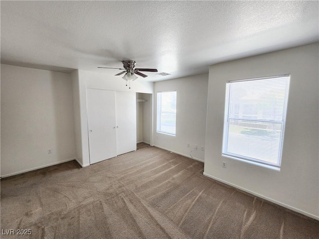 unfurnished bedroom featuring ceiling fan, a closet, carpet, and a textured ceiling