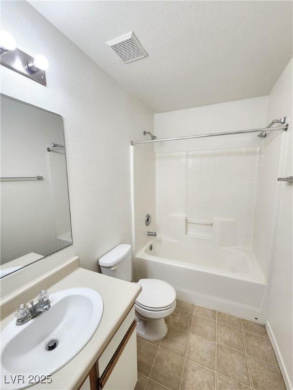 full bathroom featuring tile patterned floors, toilet, a textured ceiling, shower / tub combination, and vanity