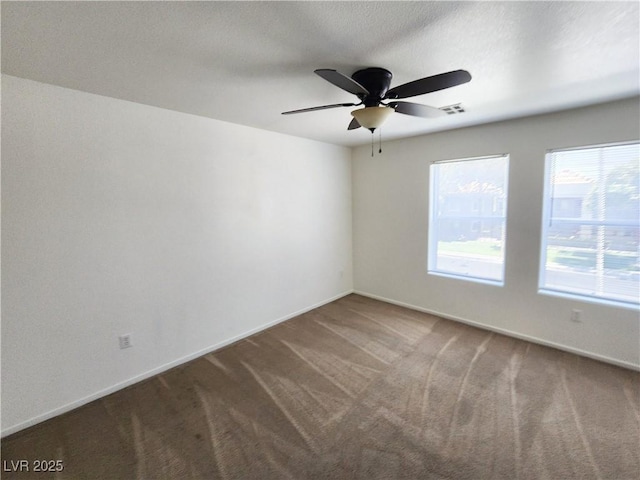 empty room with ceiling fan and carpet flooring