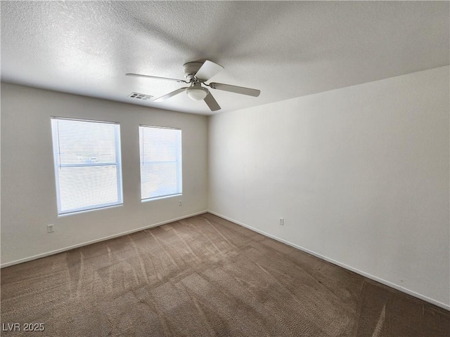 unfurnished room featuring ceiling fan, dark carpet, and a textured ceiling