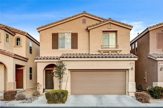 mediterranean / spanish-style house featuring driveway, a tiled roof, a garage, and stucco siding