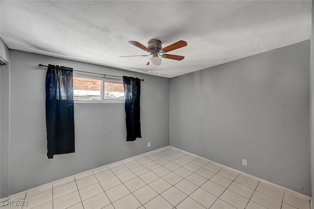 empty room featuring light tile patterned flooring, ceiling fan, and a textured ceiling