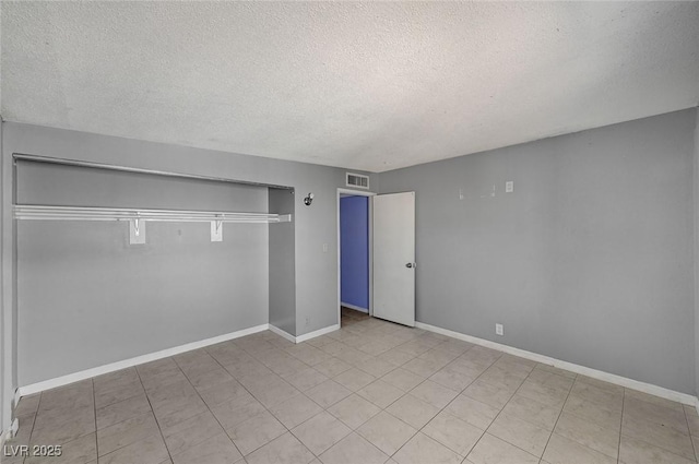 unfurnished bedroom featuring a textured ceiling and a closet