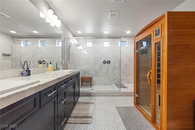 bathroom featuring tile patterned flooring, vanity, and tiled shower