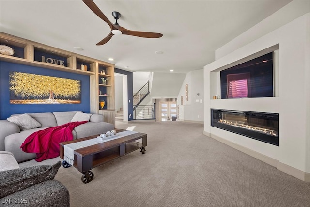 living room featuring carpet floors, ceiling fan, and built in shelves