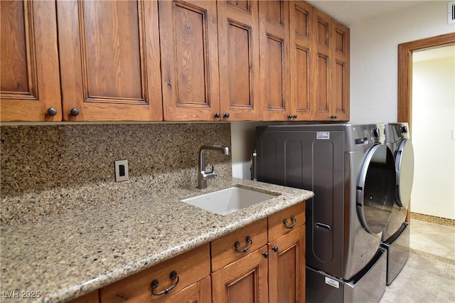 laundry area featuring sink, washer and clothes dryer, and cabinets