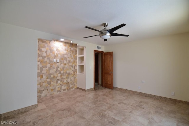 empty room featuring ceiling fan and built in shelves