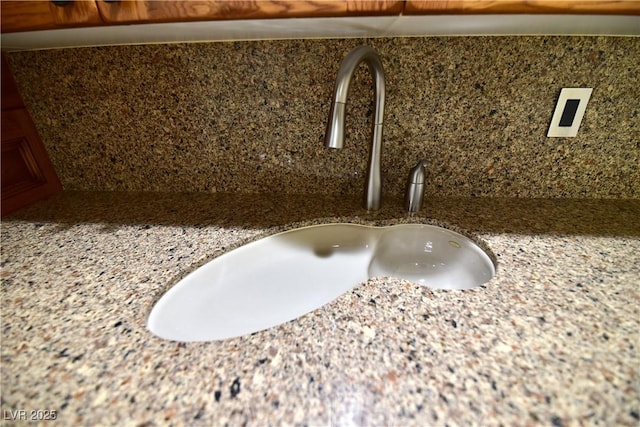 interior details featuring stone countertops and sink