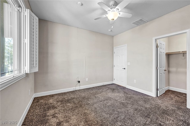 unfurnished bedroom with dark carpet and ceiling fan