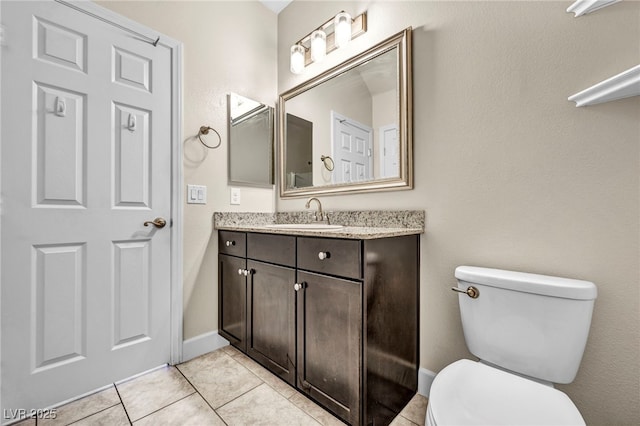 bathroom with tile patterned flooring, vanity, and toilet