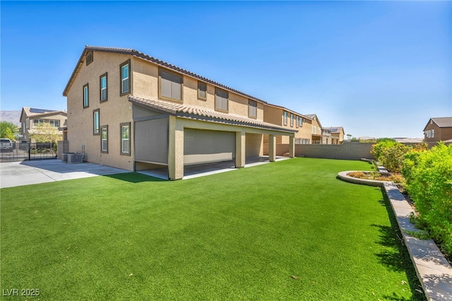 rear view of property with central air condition unit, a patio area, and a lawn