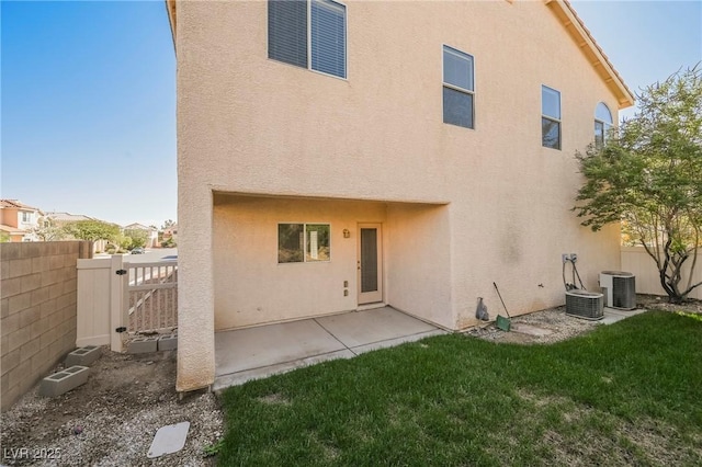 back of house featuring a patio, a yard, and cooling unit