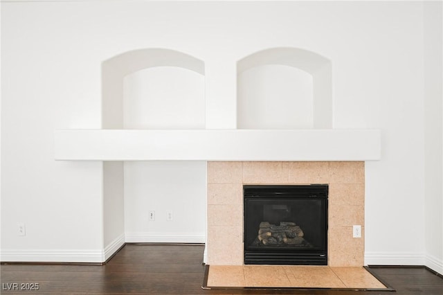 room details featuring a tiled fireplace and hardwood / wood-style floors