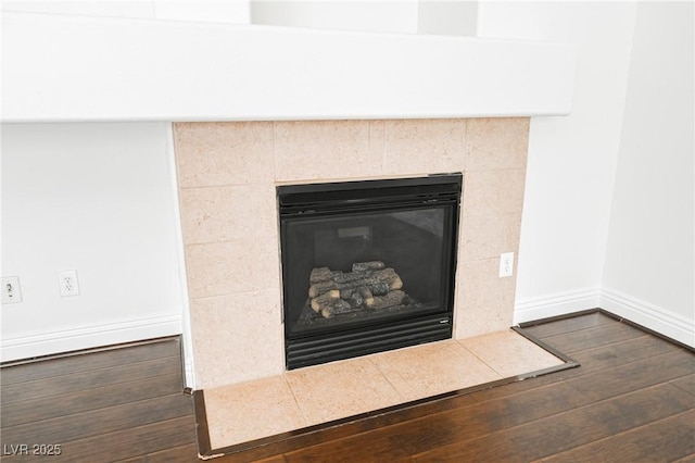 interior details with wood-type flooring and a tile fireplace