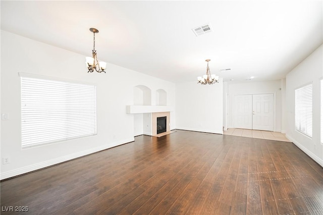 unfurnished living room featuring dark hardwood / wood-style flooring and a chandelier