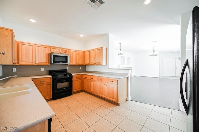 kitchen featuring light tile patterned floors, sink, hanging light fixtures, black appliances, and kitchen peninsula