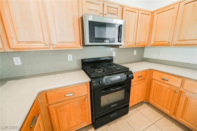 kitchen featuring gas stove and light tile patterned flooring