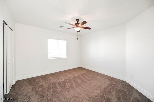 carpeted spare room featuring ceiling fan