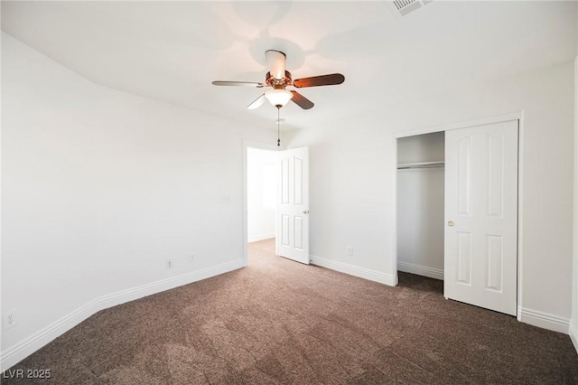 unfurnished bedroom with ceiling fan, a closet, and dark colored carpet