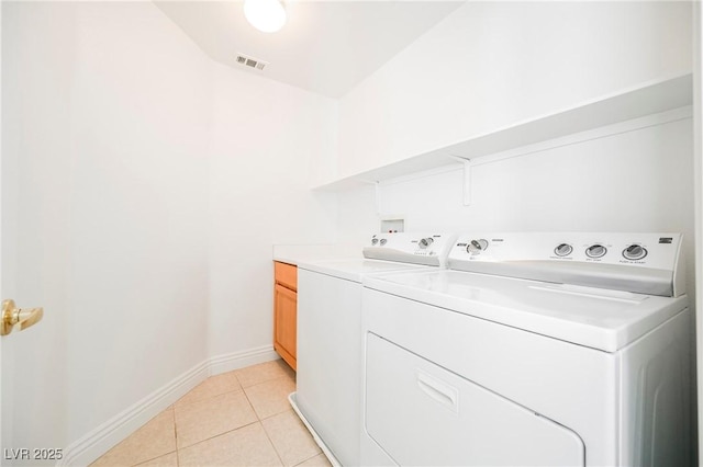 laundry room with cabinets, separate washer and dryer, and light tile patterned floors