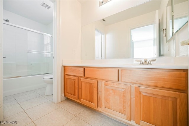 full bathroom featuring tile patterned flooring, vanity, enclosed tub / shower combo, and toilet