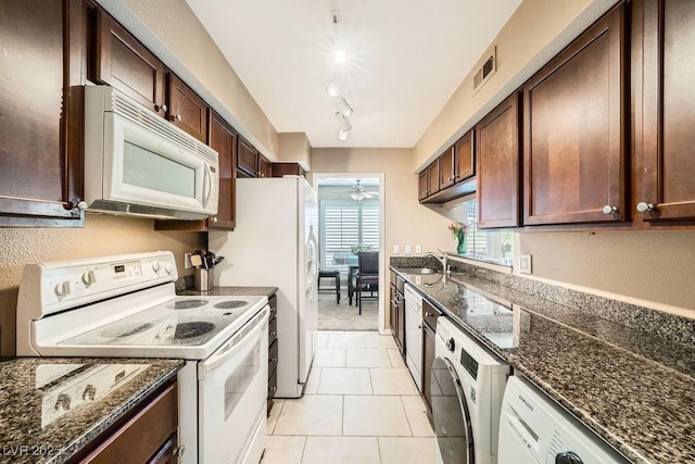 kitchen with washer / dryer, sink, dark stone counters, ceiling fan, and white appliances