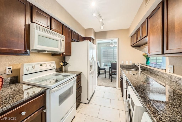 kitchen featuring light tile patterned floors, sink, white appliances, ceiling fan, and dark stone counters