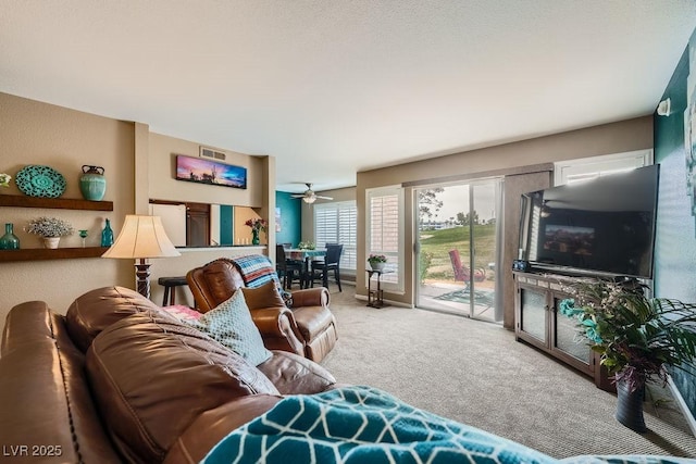 carpeted living room with ceiling fan