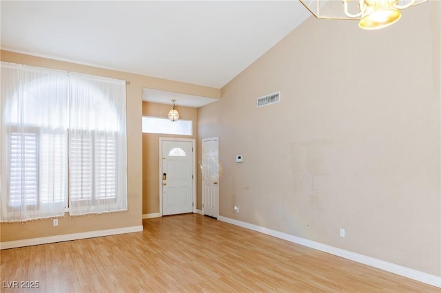 entrance foyer featuring high vaulted ceiling and light wood-type flooring