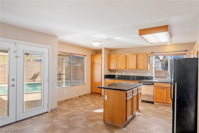 kitchen featuring french doors, sink, black fridge, stainless steel dishwasher, and a kitchen island